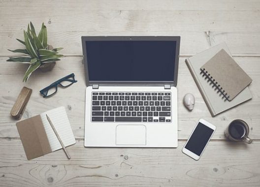 Table with laptop, mobile phone and other things